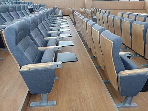 Auditorium chair with front mounted writing tablet