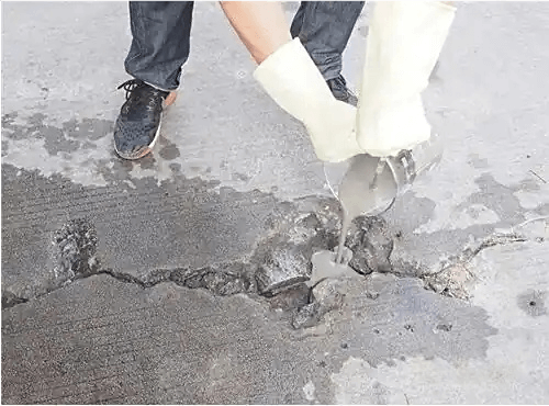 Uneven cement floor with pits and cracks, unsuitable for auditorium chair installation