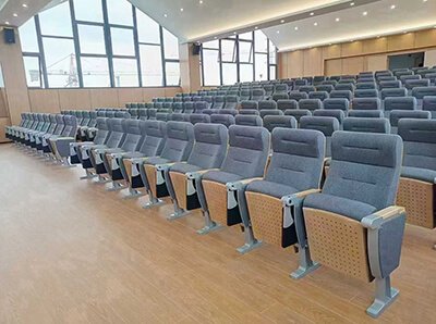 Wide-angle shot of the full auditorium after installation, highlighting the harmonious design with wooden paneling on the walls.